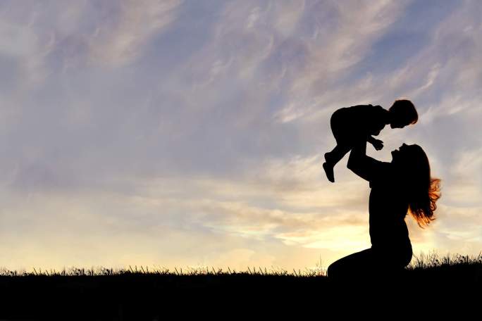 silhouette-of-happy-mother-playing-outside-with-baby